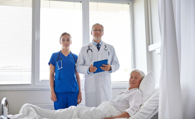 doctor and nurse visiting senior woman at hospital