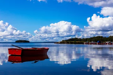 Poster Im Rahmen Red rowing boat on an idyllic bay in Sweden © fotorath