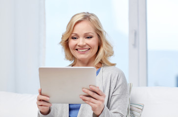 happy middle aged woman with tablet pc at home