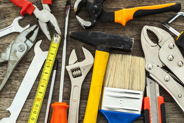 Assorted work tools on wood background