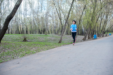 Young woman in black tights running around the Park