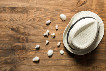 Summer hat and seashells on a wooden table