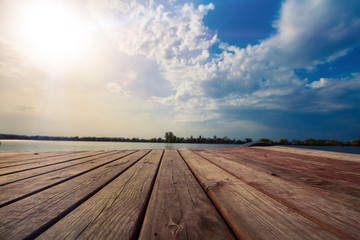 a sun lights an orthros on the small river. Wood planks floor.