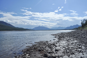 The sky in the clouds over the mountain river.