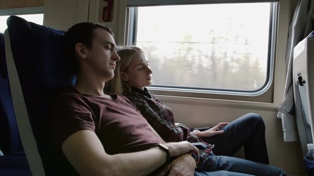 Couple traveling and sleeping in the train
