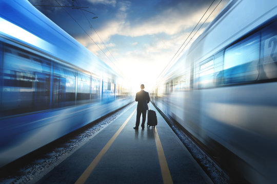 Business Man Between Two Train At The Train Station