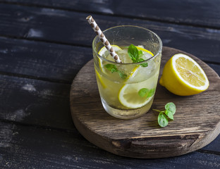 Lemon, ginger and mint lemonade on a wooden rustic board. Cold refreshing drink