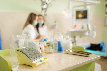 Dentistry drills, polishers and polishing brushes eraser on foreground and female dentist with assistant doing first check-up on the background. Stomatology equipment at the dental clinic - obrazy, fototapety, plakaty