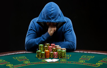 Portrait of a professional poker player sitting at pokers table 