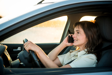Obraz na płótnie Canvas Woman driving car on phone