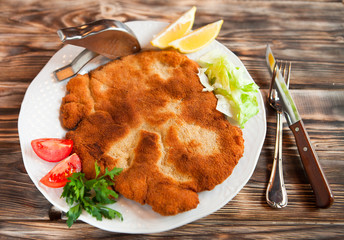 Fried pork chop coat in breadcrumbs with lemon slise and vegetab