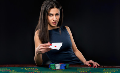 The beautiful girl, dealer, behind a table for poker - obrazy, fototapety, plakaty