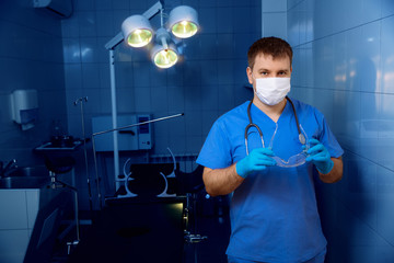 Surgeon in operative room in a mask and with glasses