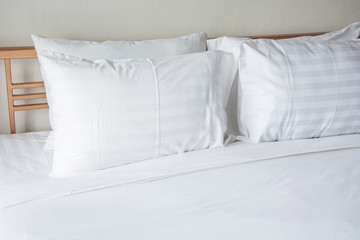 Fototapeta na wymiar white pillow on bed with white blanket in bedroom