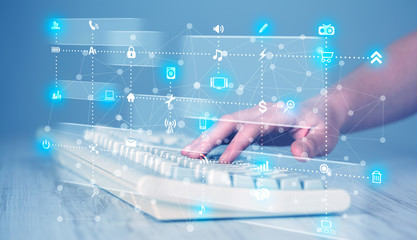 Hand pressing keyboard with high tech media icons