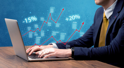 Salesman working on graph with laptop