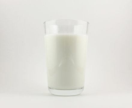 The glass of milk on white background