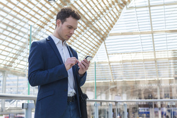 Businessman writing a message on smartphone