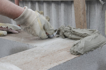 worker aligns with a spatula lay brick cinderblocks