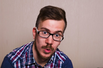 Obraz premium people surprised. guy with glasses and a beard, sitting with mouth open. hipster with surprise emotion
