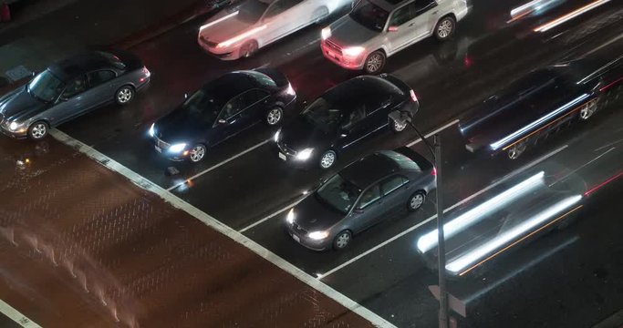 LOS ANGELES, CA, USA  - FEBRUARY 2016:  Time lapse with cars and other vehicles moving through an intersection in Downtown LA in the rain. Slow shutter creates light trails.  Loopable clip.