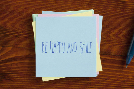 Be happy and smile handwritten on note