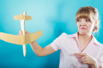 Fly fear. Woman holding airplane in hand.
