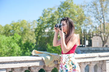 Young woman taking photo from the bridge