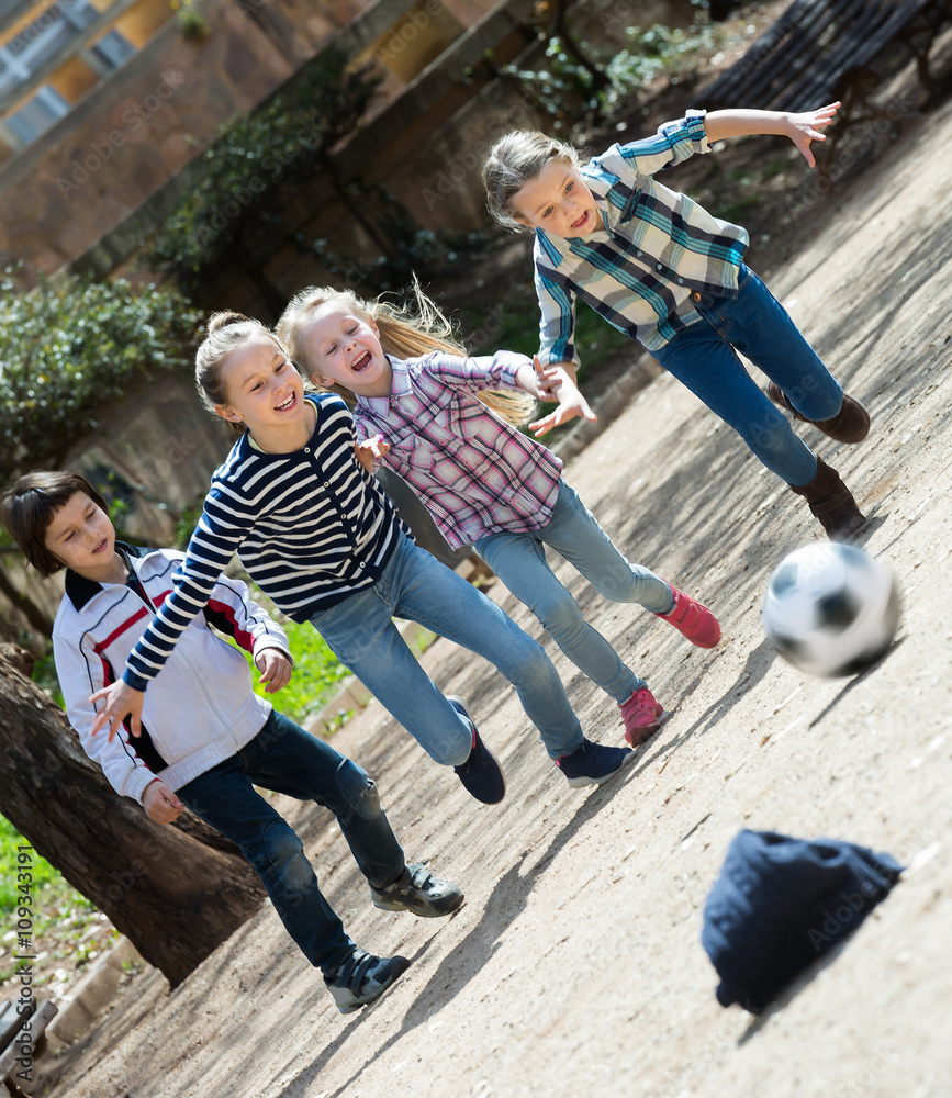 Wall mural Kids playing street football outdoors