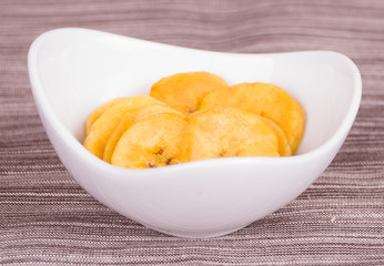Banana chips chifles lying in small white bowl