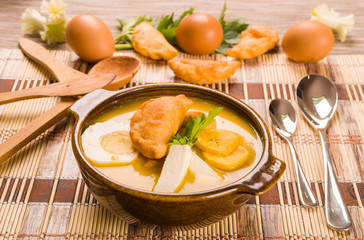 Elegant table setting with full serving of traditional fanesca soup and eggs working as decor
