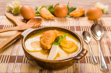 Elegant table setting with full serving of traditional fanesca soup and eggs working as decor