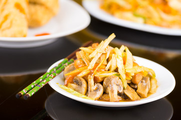 Traditional chinese food, noodles, mushrooms and vegetables on a white dish