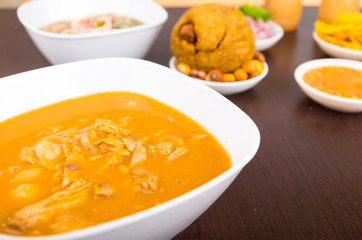 Special dish soup with onion served on a white dish, behind some traditional food