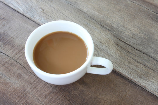 White coffee cup on a wooden floor.