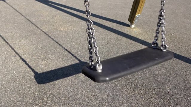 Empty swing at playground with no children around.
