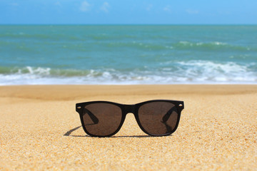 Fototapeta na wymiar Black sunglasses on the beach