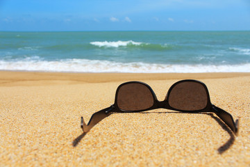 Fototapeta na wymiar Black sunglasses on the beach