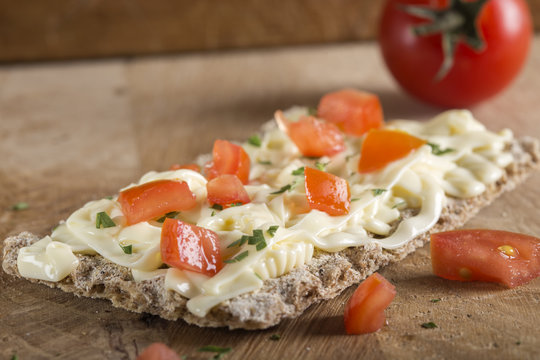 Crispbread with cheese, tomato and herbs