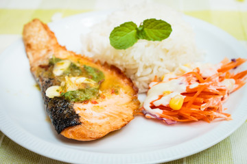 Rice and salmon steak with spicy sauce.