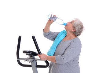 female senior train with fitness machine and drinking water