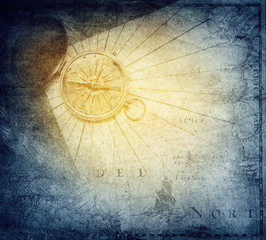 Vintage golden compass with nautical map background.