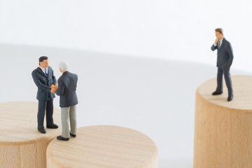 交渉成立したビジネスマンとそれを見るビジネスマン