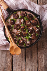 Swedish cuisine: kottbular with cowberry sauce on a pan. vertical top view
