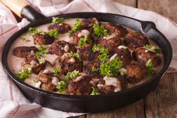 Swedish cuisine: kottbular with cowberry sauce closeup on a pan. horizontal
