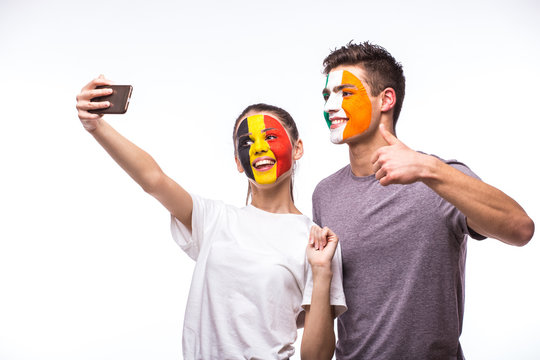 Belgium vs Republic of Ireland football fans take selfie photo with phone on white background. European football fans concept.