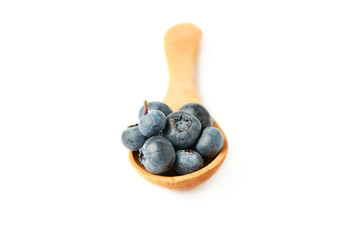 Wooden spoon filled of Bilberry or blueberry over isolated white background