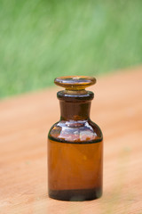 little brown bottle on booden board and grass