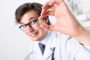 Blurry doctor holding pill
