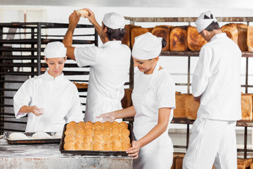 Baker Looking At Baked Breads In Bakery